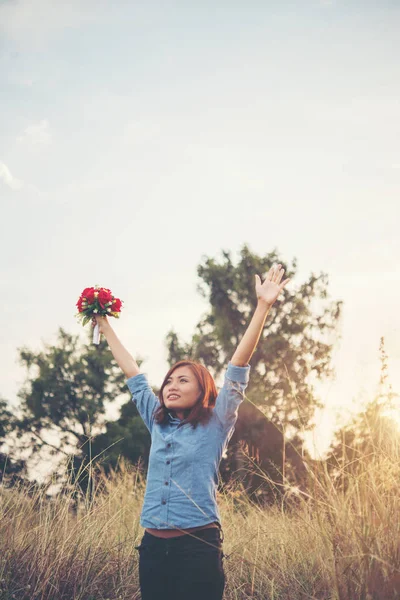 Όμορφη γυναίκα hipster αυξάνοντας το χέρι στον αέρα με μπουκέτο — Φωτογραφία Αρχείου