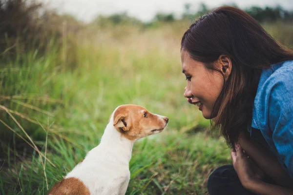 Feliz alegre hipster menina brincando com seu cão no parque dur — Fotografia de Stock