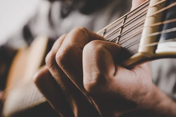 Zbliżenie dłoni mężczyzna gra na gitarze. — Zdjęcie stockowe