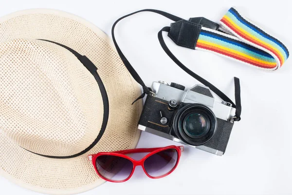 Hat sunglasses and vintage camera isolated on a white background