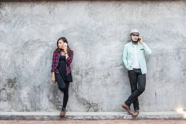 Пара разговаривает с мобильным на кирпичной стене, винтаж, гранж backgrou — стоковое фото