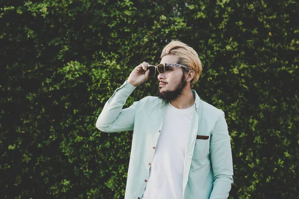 Handsome young hipster man in glasses looking away while standin — Stock Photo, Image