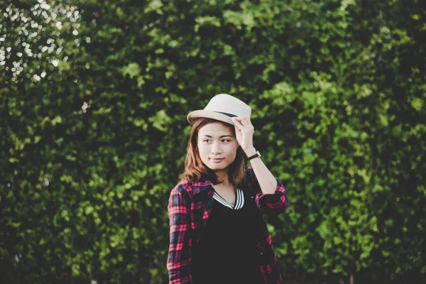 Hermosa mujer hipster de pie cerca de la planta de árbol verde en la ciudad p —  Fotos de Stock