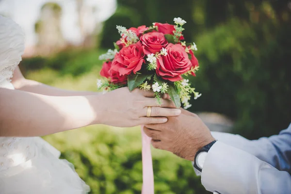 Der Bräutigam schenkt der Braut mit Naturhintergrund einen Strauß. — Stockfoto