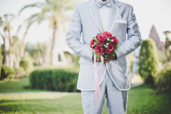 Groom with red rose bouquet. — Stock Photo, Image