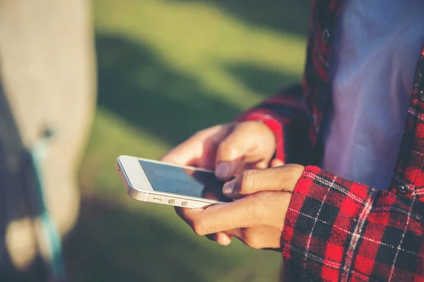 Young woman using a smartphone outdoors at park. — Stock Photo, Image