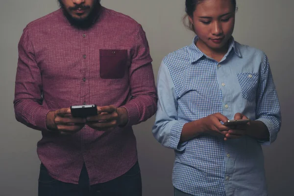 Happy couple sending text messages on black background.