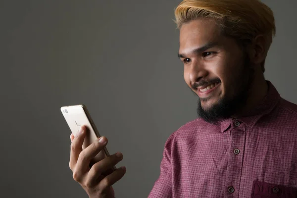 Snygg hipster mannen leende medan du använder smartphone isolerad på — Stockfoto