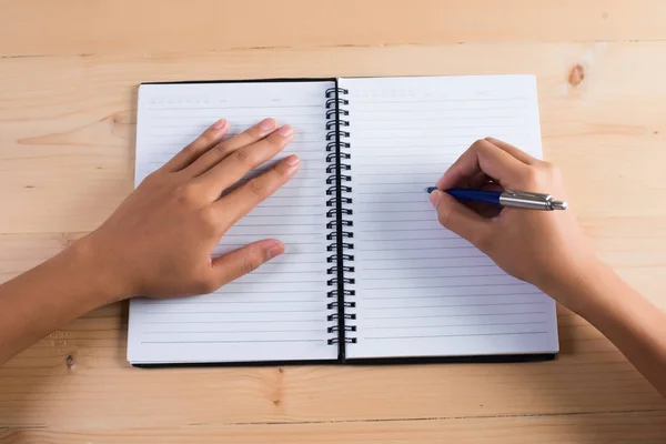 Ovanifrån av kvinnans hand skriva på anteckningar. — Stockfoto