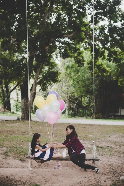 Μητέρα Την Κόρη Που Κάθεται Στο Swing Πολύχρωμα Μπαλόνια Χαλαρωτική — Φωτογραφία Αρχείου