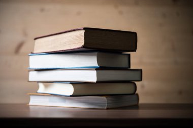 Ahşap masa üzerinde kitap yığını. Eğitim kavramı.