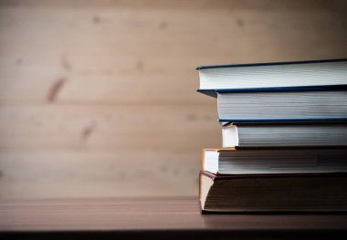 Ahşap masa üzerinde kitap yığını. Eğitim kavramı.