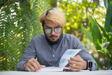 Genç hipster sakal adam ev bahçe doğa ile kitap okuma. Eğitim kavramı.