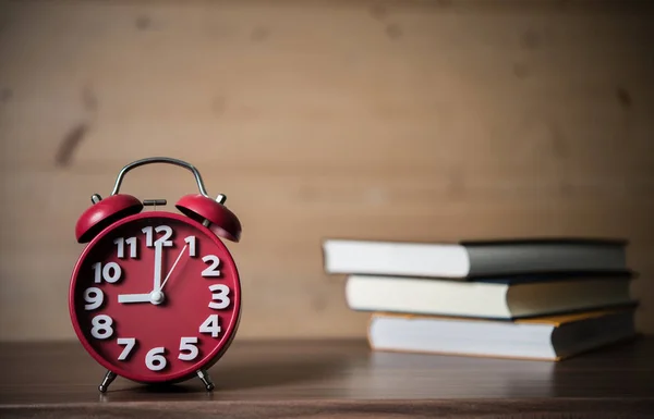 本と木製のテーブルの上の目覚まし時計 教育コンセプト — ストック写真