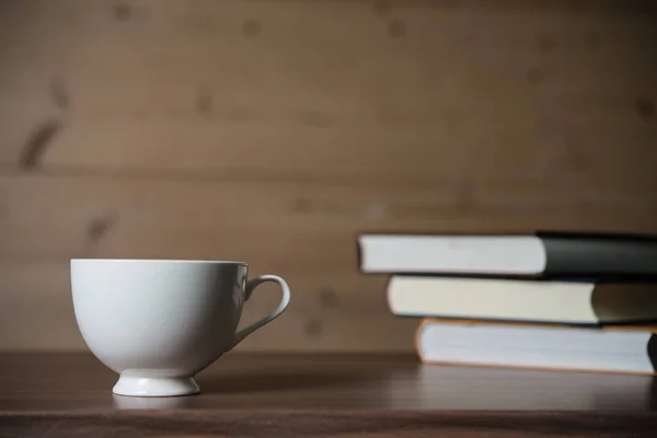 Books with coffee on wooden background