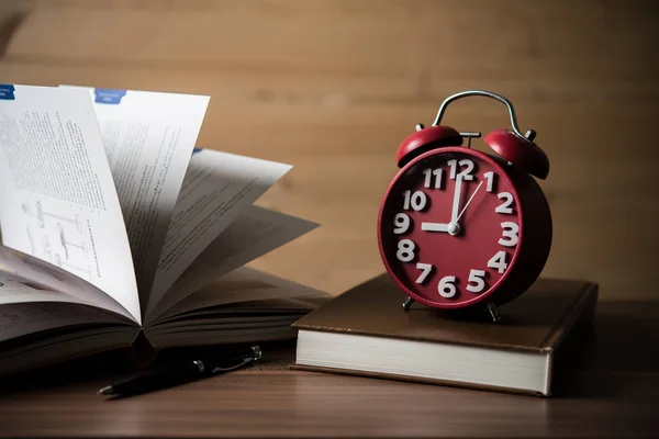 本と木製のテーブルの上の目覚まし時計 教育コンセプト — ストック写真