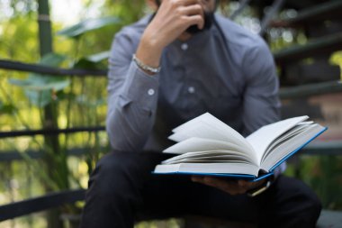 Genç hipster sakal adam ev bahçe doğa ile kitap okuma. Eğitim kavramı.