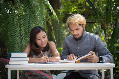 Eğitim çift doğa ev bahçesinde oturan zaman okuma ve öğretici sınavı birlikte için. Eğitim insanlar kavramı.