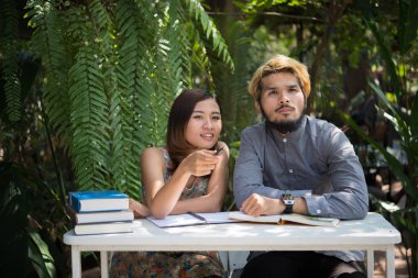 Eğitim çift doğa ev bahçesinde oturan zaman okuma ve öğretici sınavı birlikte için. Eğitim insanlar kavramı.