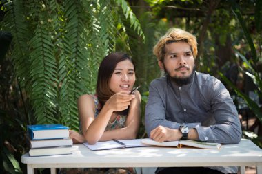 Eğitim çift doğa ev bahçesinde oturan zaman okuma ve öğretici sınavı birlikte için. Eğitim insanlar kavramı.