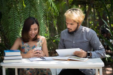 Eğitim çift doğa ev bahçesinde oturan zaman okuma ve öğretici sınavı birlikte için. Eğitim insanlar kavramı.