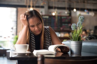 Asyalı kadın rahatlatıcı ve kafede bir kitap okuma. Kadın yaşam tarzı kavramı.