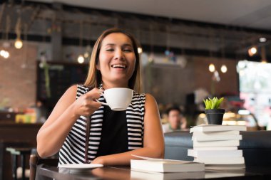 Asyalı kadın rahatlatıcı ve kafede bir kitap okuma. Kadın yaşam tarzı kavramı.