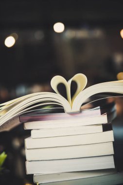 Masa bulanık Kütüphane arka plan üzerinde kitap yığınları.