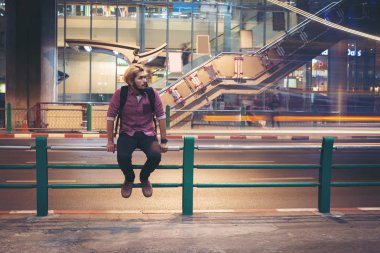 Hipster geceleri seyahat ederken korkuluk araba hareket arka plan üzerinde oturan adam sakallı.