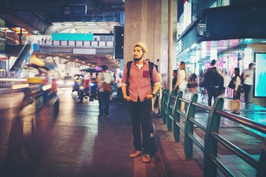 Yakışıklı sakallı adam ayakta yol kenarında gece bangkok şehir Tayland seyahat ederken sokak.