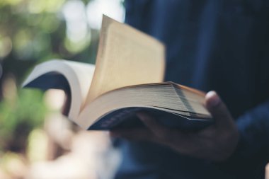 Kadının elinde kitap okumaya tutarak yakın çekim.