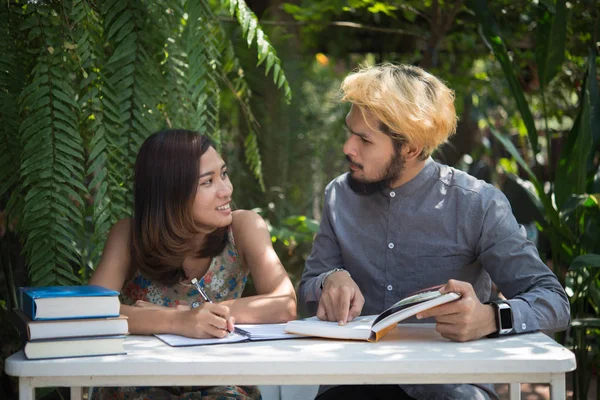 Education couple sitting at nature home garden, time to reading and tutorial for exam together. Education people concept.