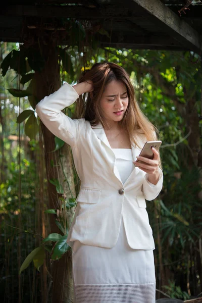Young business woman standing looking at phone stressed out and upset with it at morning before go to work.