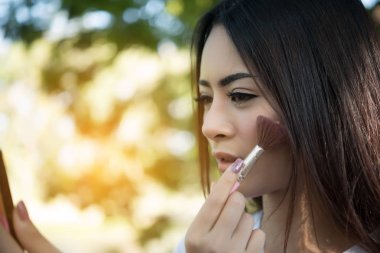 Genç güzel kadın makyaj fırça yanağındaki yapma. Kadın yaşam tarzı kavramı