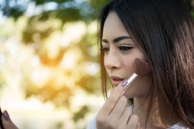 Genç güzel kadın makyaj fırça yanağındaki yapma. Kadın yaşam tarzı kavramı