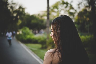 Genç güzel kız üzgün parkta duran o hayal kırıklığına uğramış ve yalnız.