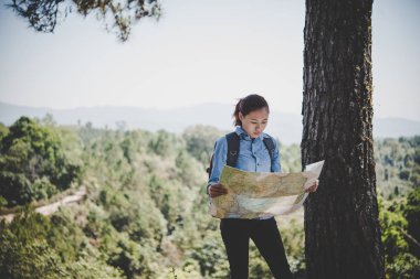 Genç kadın backpacker fiyatı hiking çelme takmak harita okuma. Tatile rahatlatıcı.