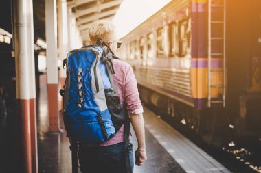 Genç hipster turistik tren istasyonu sırt çantası ile. Tatil turist kavramı.