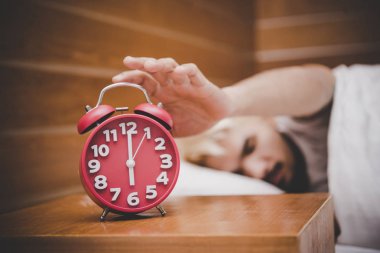 Sabah uyanma Alarmı kapatmak çalışan adam.