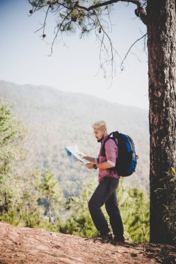 Uzun yürüyüşe çıkan kimse harita ve büyük Dağı'na seyahat sırt çantası seyahat ile.