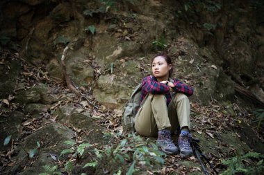 Kadın fiyatı yakındaki şelale oturan bir dinlenme alarak ormandaki zevk doğa ile.