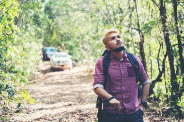 Macera genç adam bir sırt çantası ile dağlarda hiking.