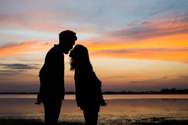 愛のシルエットの若いカップルは日没時に楽しい時間を一緒に楽しむ — ストック写真