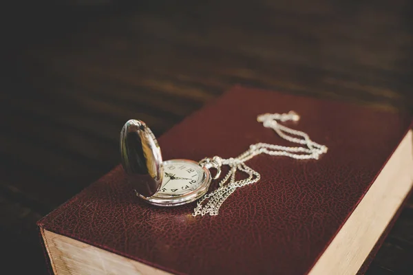 Close up of vintage pocket watch on old books.