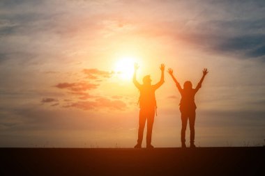 Siluetleri günbatımı zevk sırt çantaları ile iki yürüyüşçü. Seyahat kavramı.