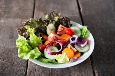 ahşap zemin üzerinde taze sebze salatası.