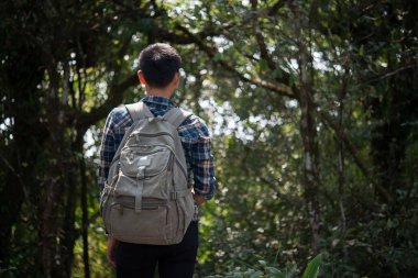 Genç hipster adam uzun yürüyüşe çıkan kimse almak biraz dinlenme vahşi dağ orman manzara zevk yürüyüş sırasında.