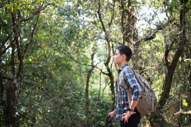 Genç hipster adam uzun yürüyüşe çıkan kimse almak biraz dinlenme vahşi dağ orman manzara zevk yürüyüş sırasında.