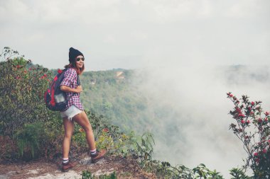 Bir dağın tepesinde duran ve doğa manzarayı sırt çantaları ile yürüyüş.
