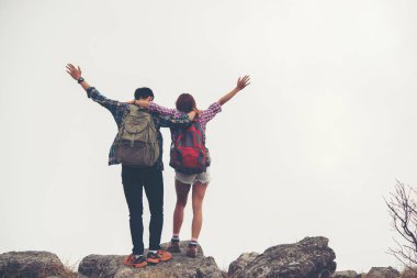 Yürüyüşçüler çift bir dağın tepesinde duran ve doğanın keyfini sırt çantaları ile göster